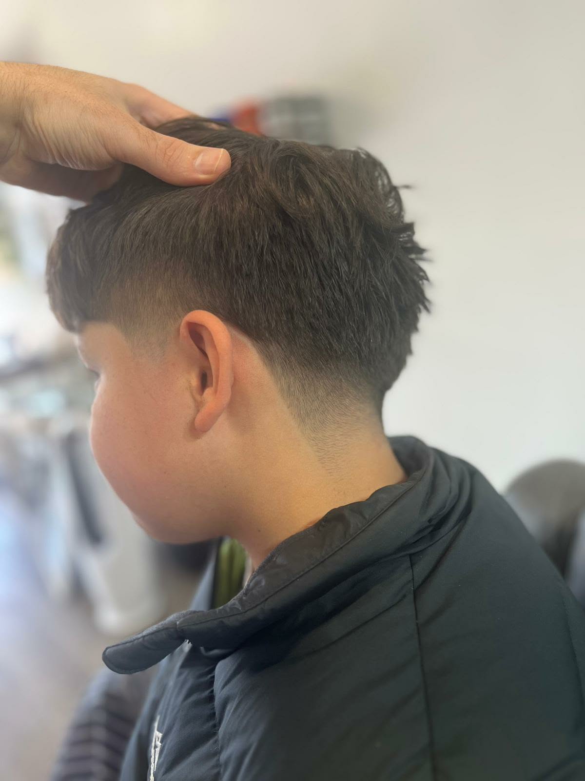 Kids textured fringe with a tapered fade at Castle Barbers