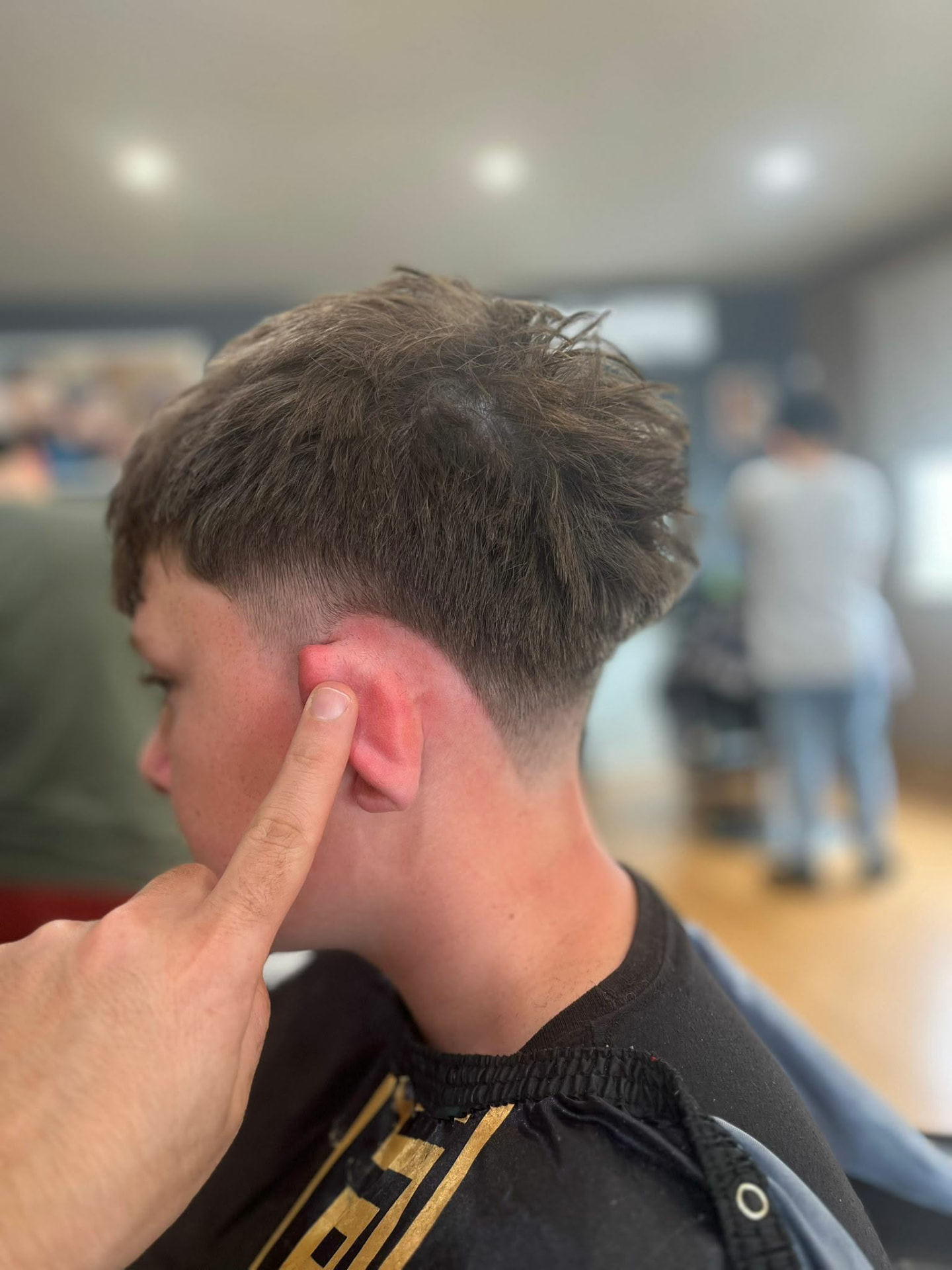 Low taper fade with a scissor-cut top at Castle Barbers